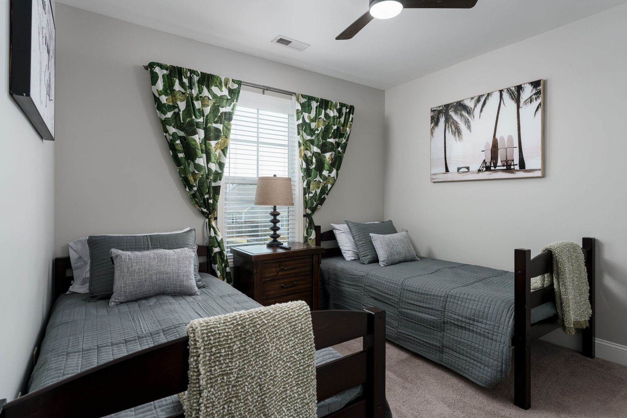Twin bedroom with two separate beds and green patterned curtains