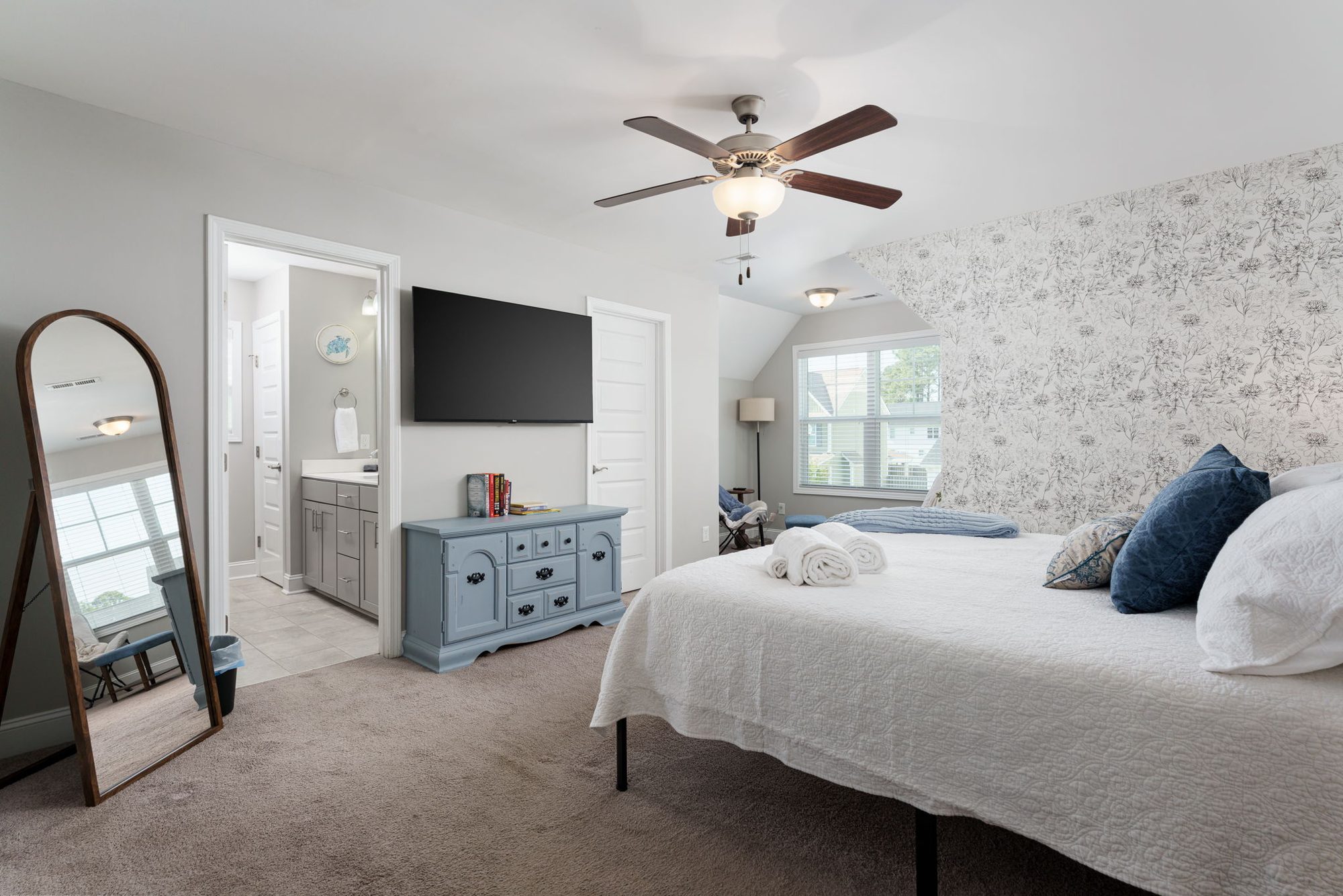 Primary king suite with upholstered bed and mirrored alcove